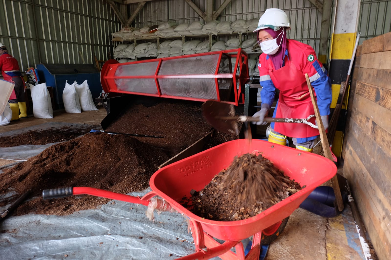 Salah seorang pekerja Segregation Plant membuat pupuk kompos dari bahan baku kayu dan daun atau bahan organik lainnya, yang merupakan sampah yang dikumpulkan.