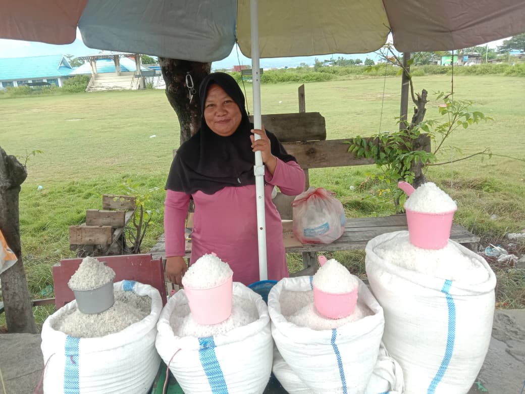 HARGA NAIK:  Pedagang garam Talise, Inar saat ditemui di lapaknya pada Senin (18/8/2025). Harga garam Talise kini naik karena hujan turun beberapa hari terakhir.