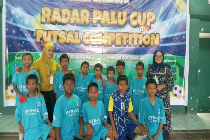 PETIK KEMENANGAN : Faega (belakang kiri) dan Sri Wahyuni Latopada (belakang kanan) Tim futsal Madrasah Ibtidaiyah Swasta Alkhairaat Boyaoge usai bertanding dalam Radar Palu Cup Futsal Competition.