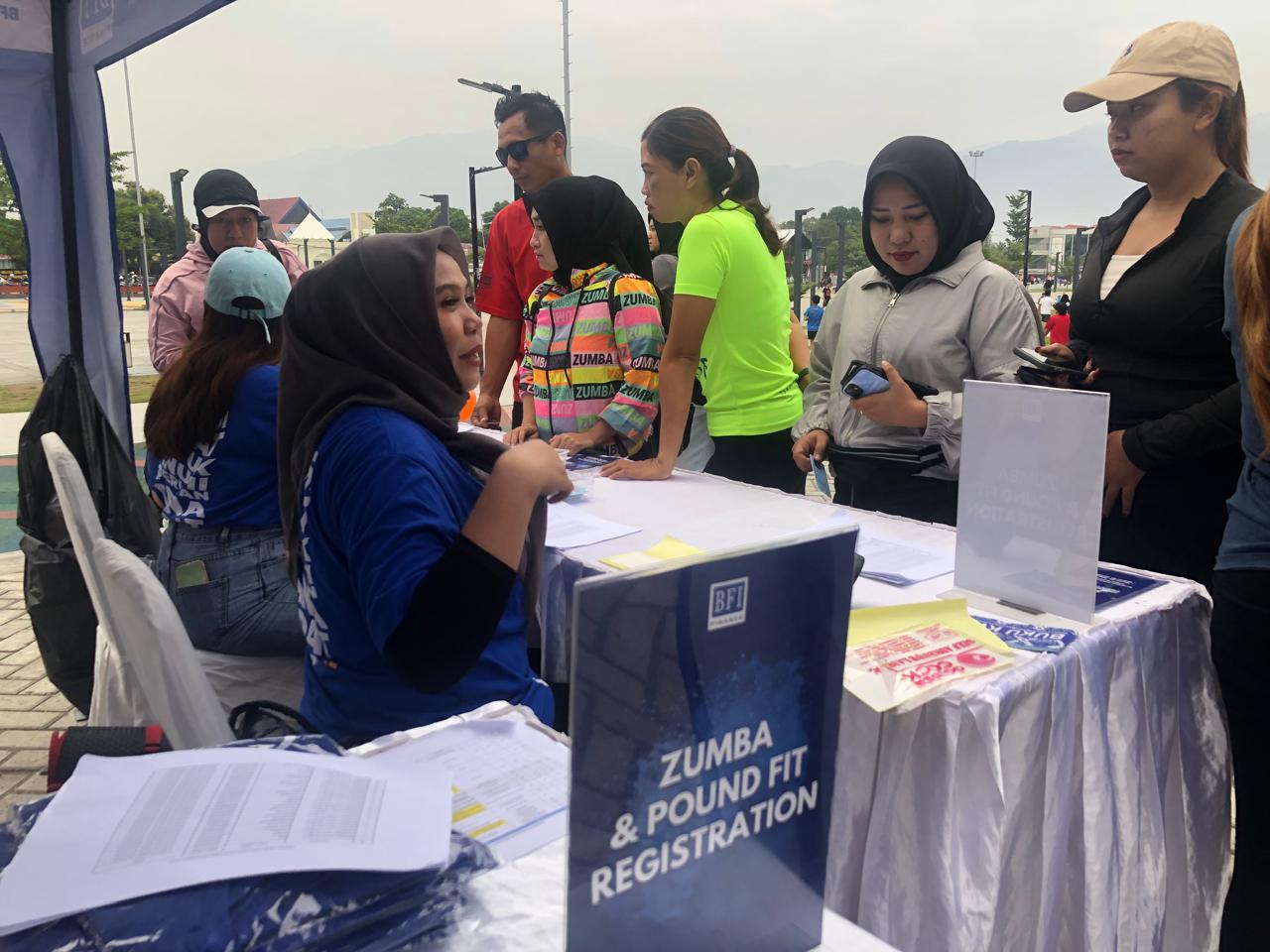 LAYANAN RAMAH: Warga Palu mengantri untuk mendaftarkan diri mengikuti Zumba Party di stan registrasi di area Lapangan Vatulemo, pada Minggu pagi (24/8/2025).