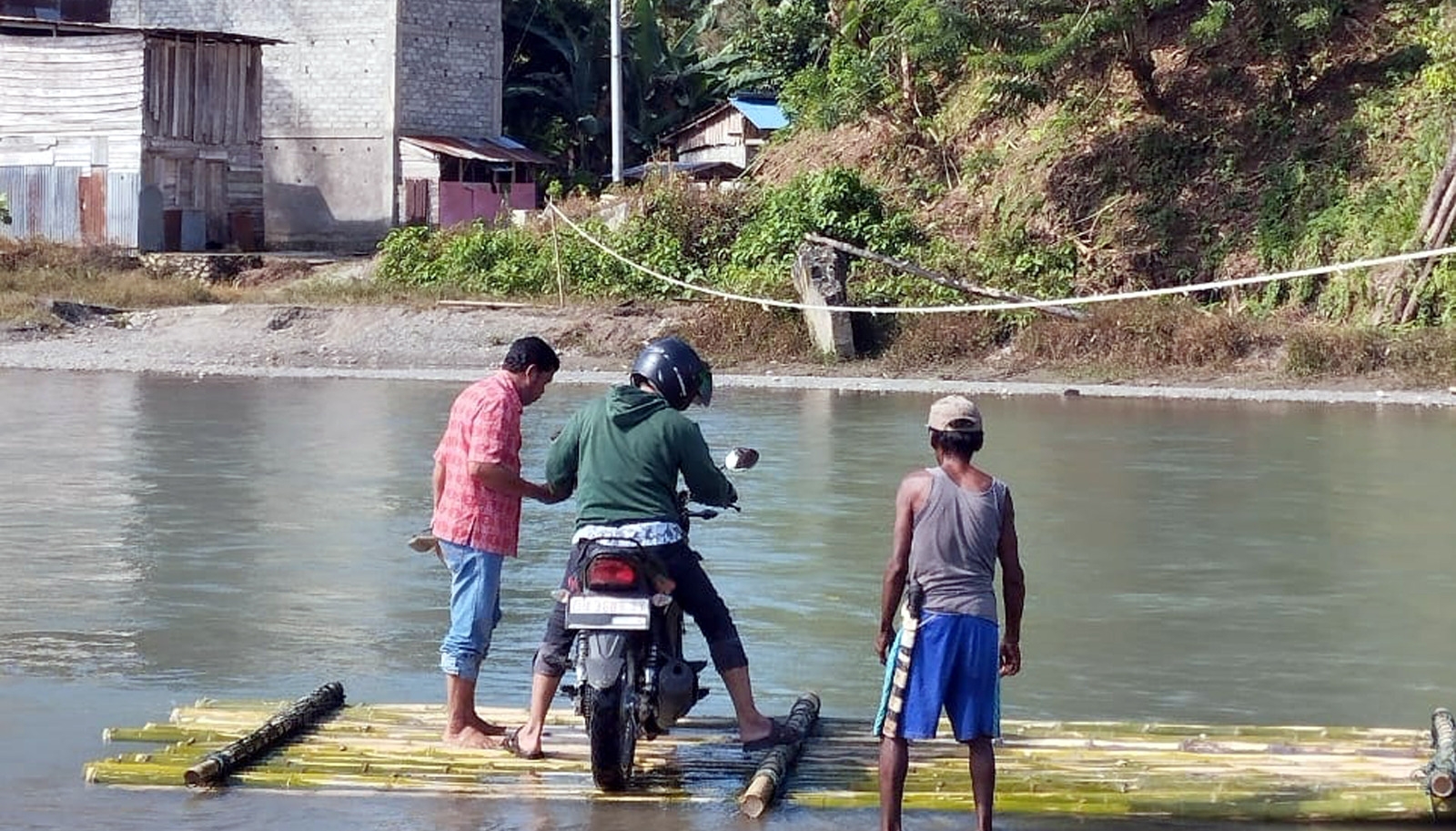 MENYEBRANG : Anggota DPRD Sulteng dari Fraksi PKS, Takwin, saat menyebrang sungai menuju gereja.(FOTO: DOK HUMAS PKS SULTENG/RADAR PALU).