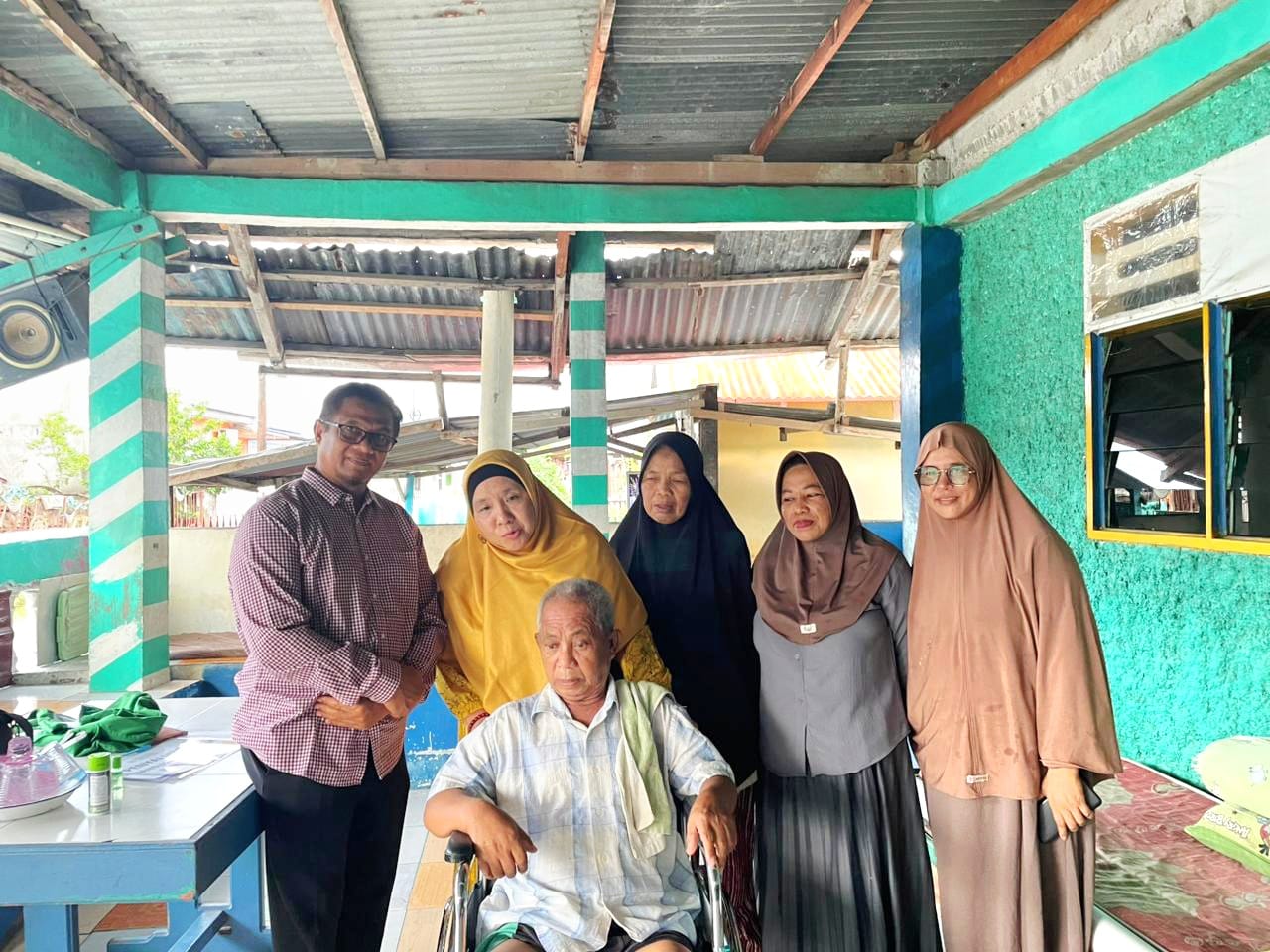 EMPATI BERBAGI : Bunda Wiwik setelah menyerahkan kursi roda untuk bapak Rusman.(FOTO: HUMAS PKS SULTENG/RADAR PALU).