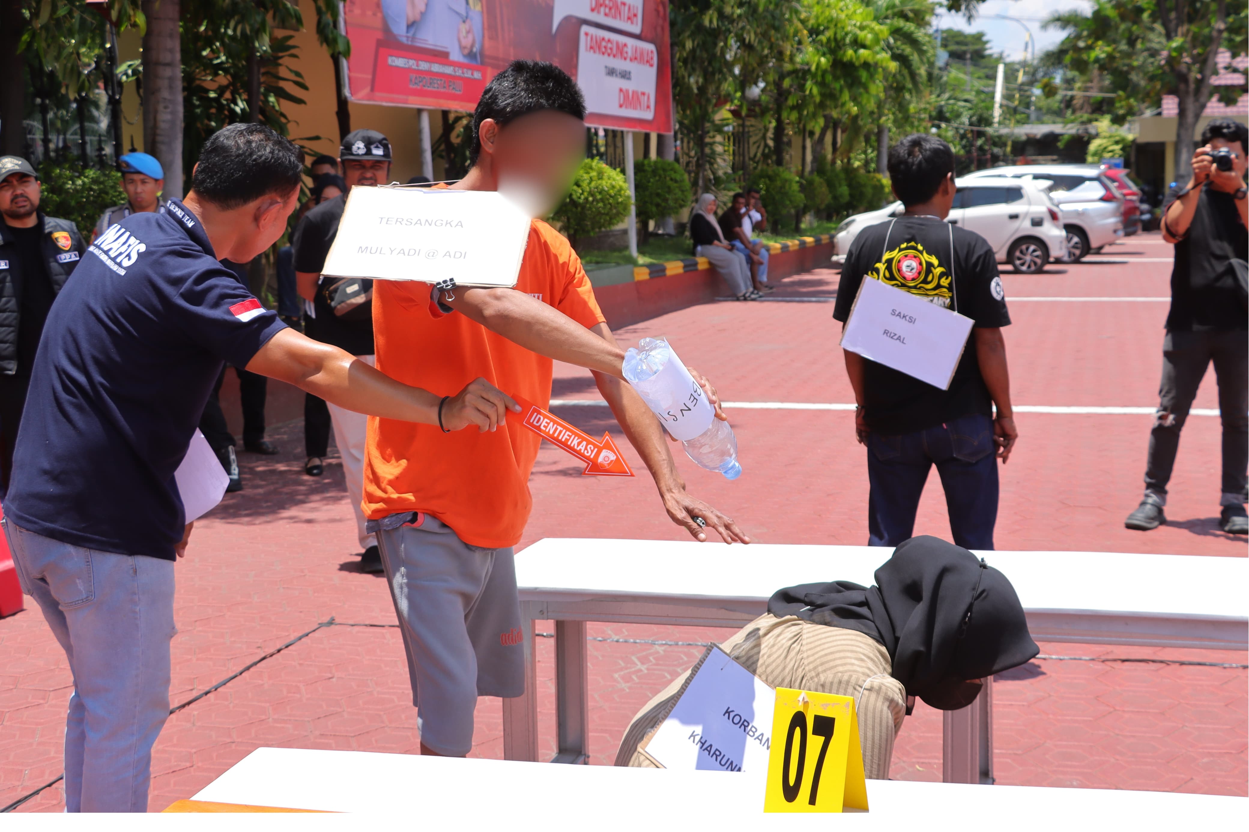 Tersangka M (42) memperagakan salah satu adegan rekonstruksi kasus pembakaran istri.