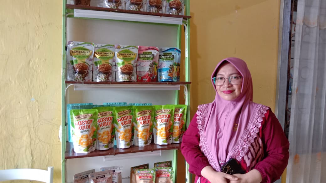 FOKUS PRODUKSI OLEH-OLEH: Owner Zamzam KS, Jaliha Rorimpandey berfoto bersama produknya pada Senin (6/10/2025). Dirinya kini fokus mengembangkan produk oleh-oleh.