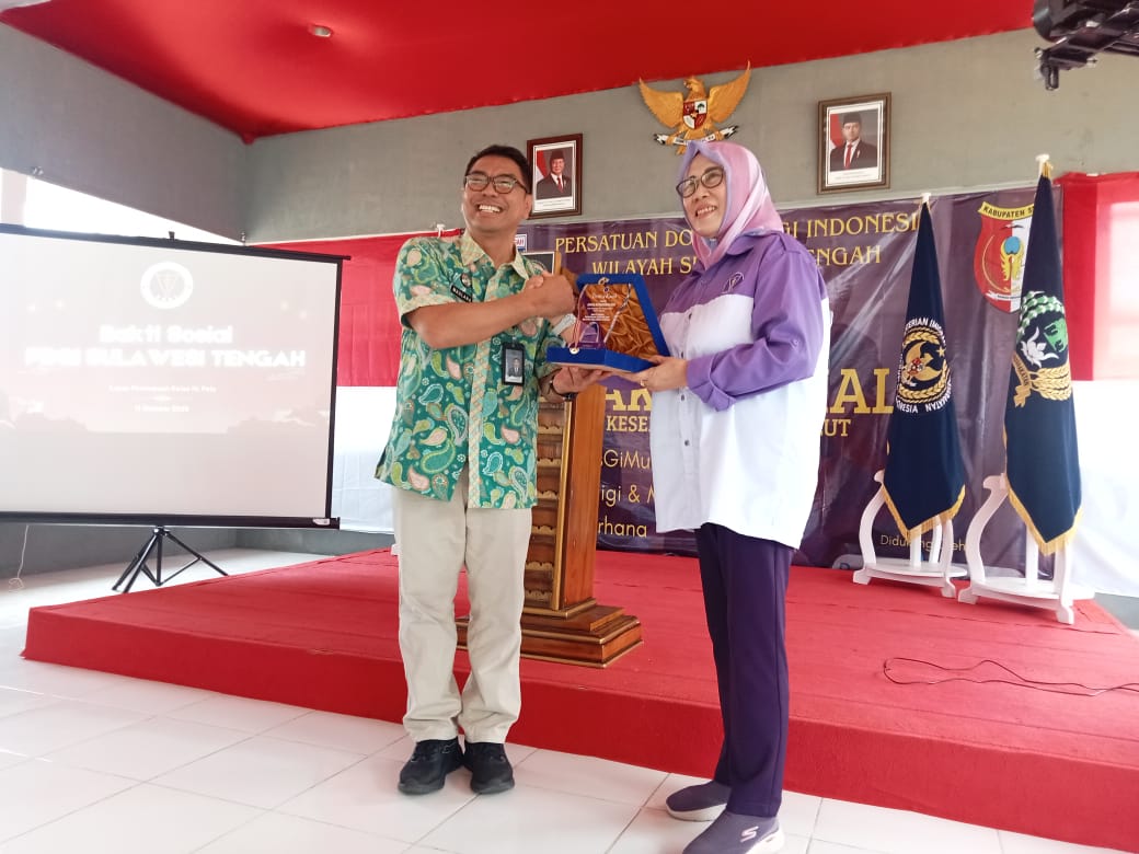 Ketua PDGI Sulteng, drg Emma Sukmawati memberikan cinderamata kepada kepala bagian umum dan tata usaha kanwil Ditjenpas, Maulana. FOTO: AGUNG