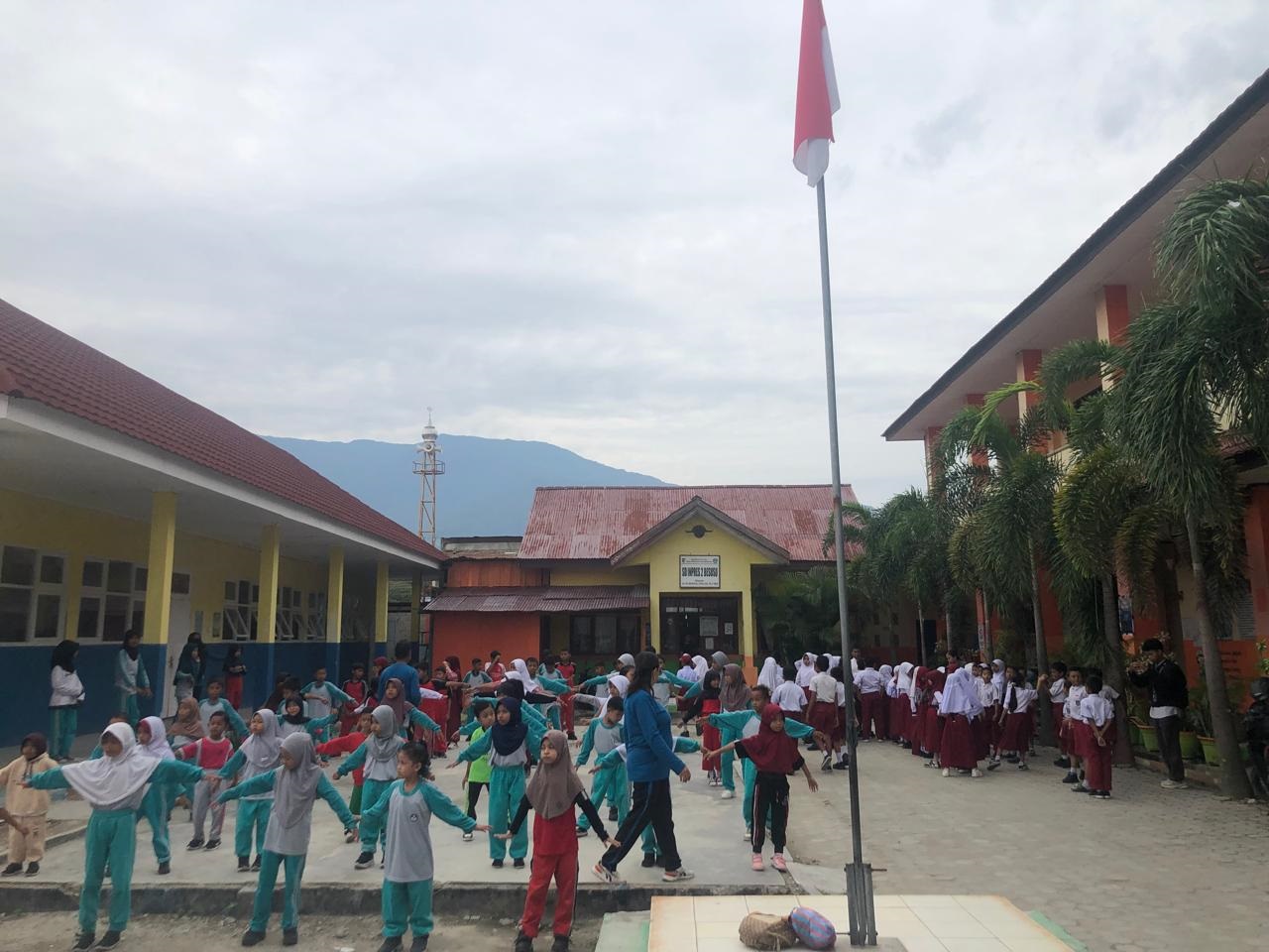 BERBAGI HALAMAN: Siswa SDN 26 Palu melakukan senam pagi di halaman sekolah. Mereka berbagi halaman dengan SD Inpres 2 Besusu, yang melakukan apel pagi.