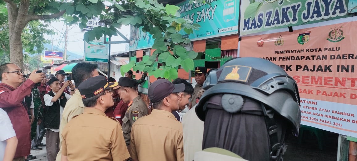 PAJAK TURUN : Bapenda Kota Palu dan instansi terkait saat melakukan penyegelan WSL yang tak patuh bayar pajak.