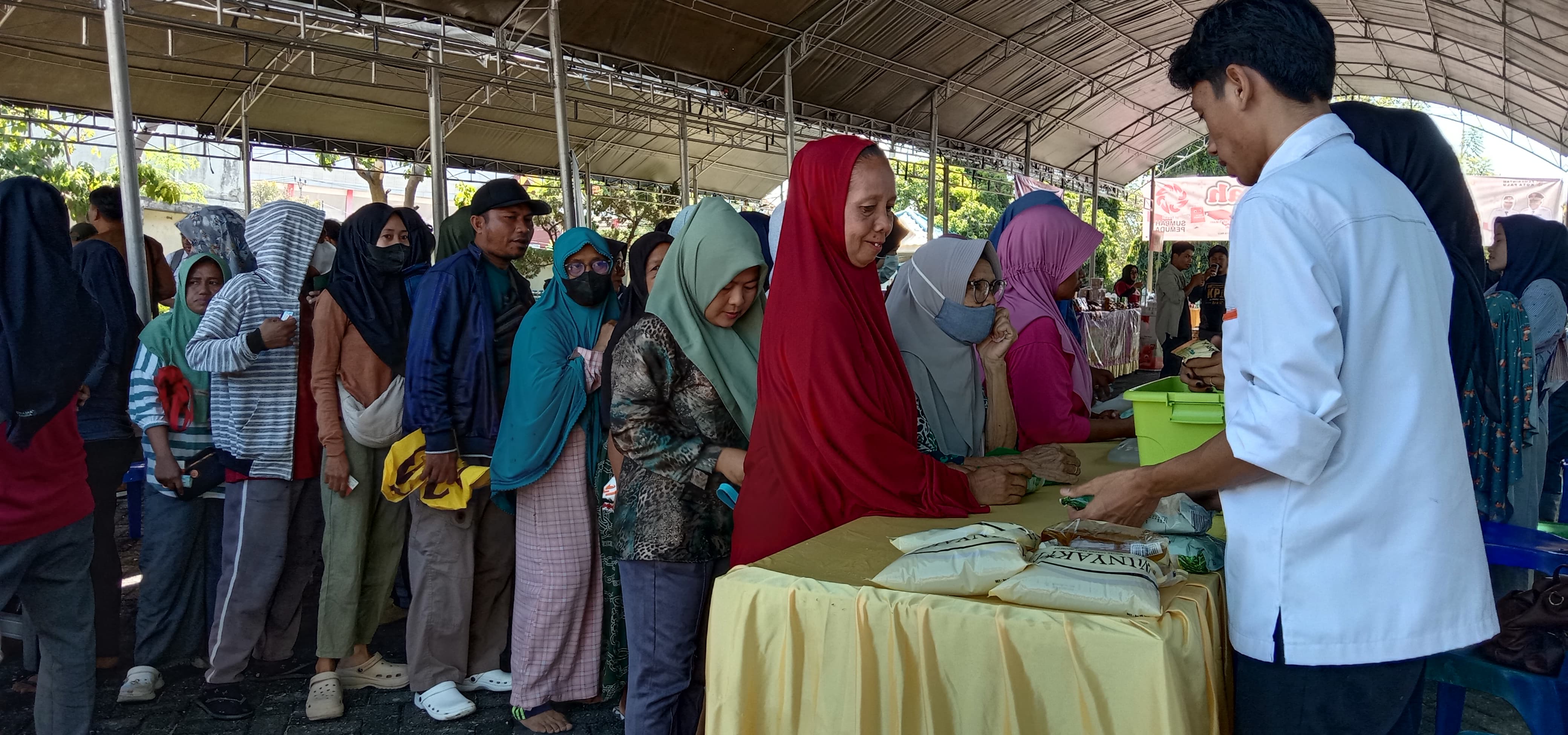 RINGANKAN KEBUTUHAN SEHARI-HARI: Masyarakat mengantre minyak di Pasar Murah Disperdagind Kota Palu bekerjasama dengan Radar Palu di Halaman Kantor Radar Palu Jalan Yos Sudarso, Kelurahan Talise.