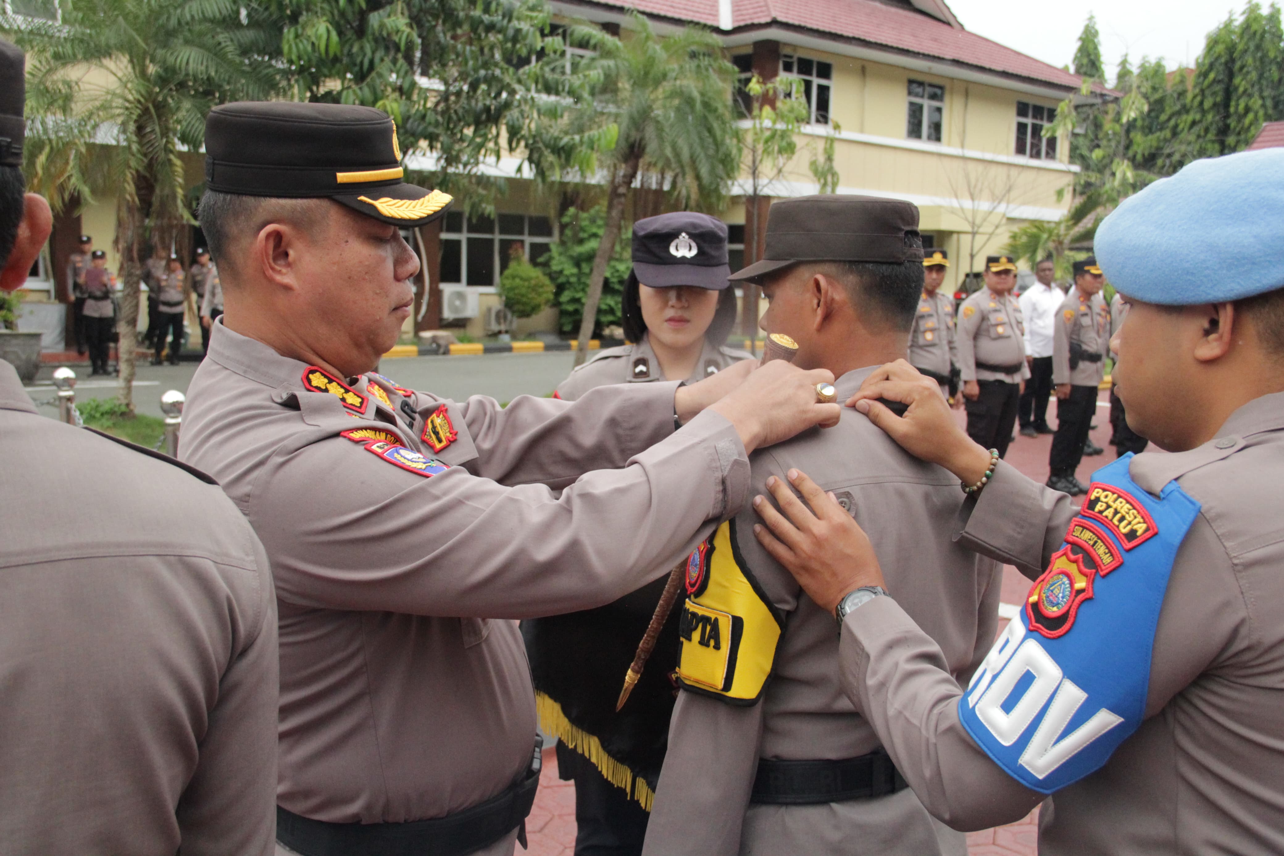 PENGAMANAN KOTA : Kapolresta Palu Kombes Pol Deny Abrahams, menyematkan tanda Program Pamapta kepada perwakilan personel Polresta Palu sebagai simbol resmi peluncuran program peningkatan kesiapsiagaan