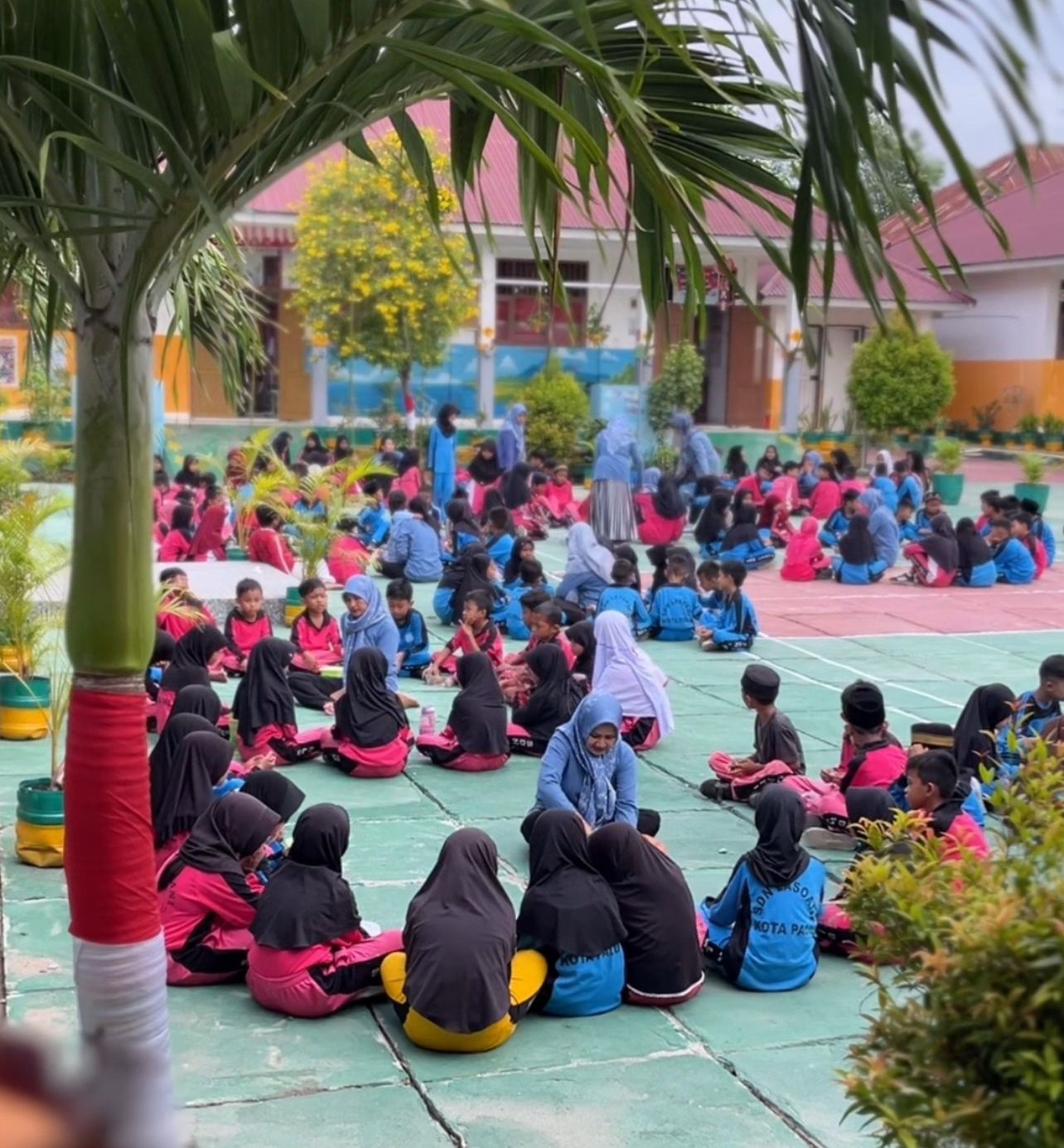 NIKMATI MAKANAN SEHAT: Moment siswa-siswi SDN Lasoani duduk bersama dilapangan menikmati makanan sehat.