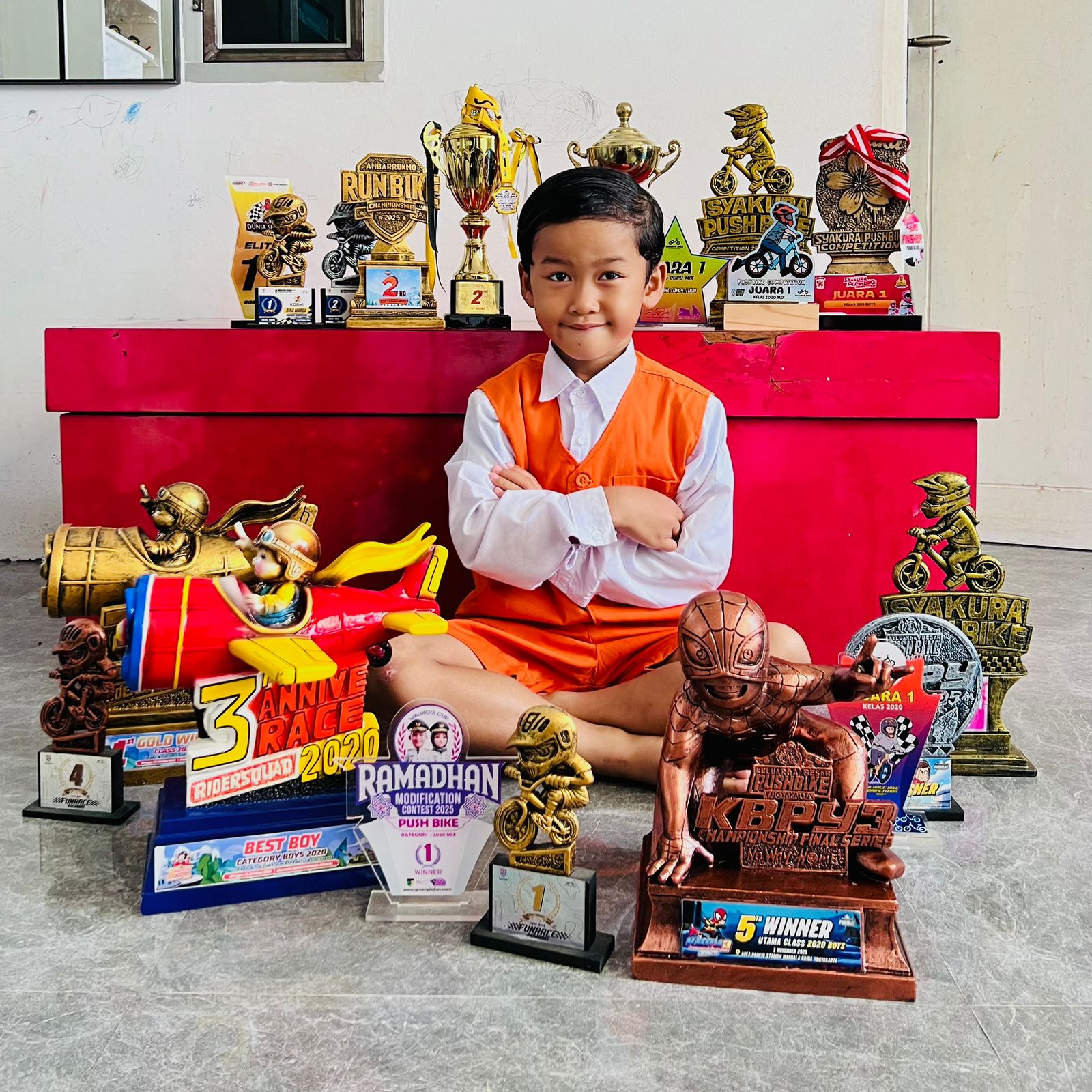 Adeaorta Rahman Assyahidd, dengan sejumlah piala yang diraih dari ajang olahraga pushbike. FOTO: IST