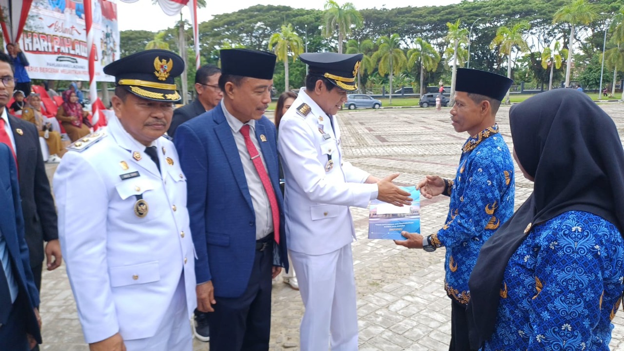 PENGHARGAAN : Bupati Parimo Erwin Burase bersalaman dengan salah seorang ASN di Parimo.(FOTO: ROY LASAKKA/ISTIMEWA).