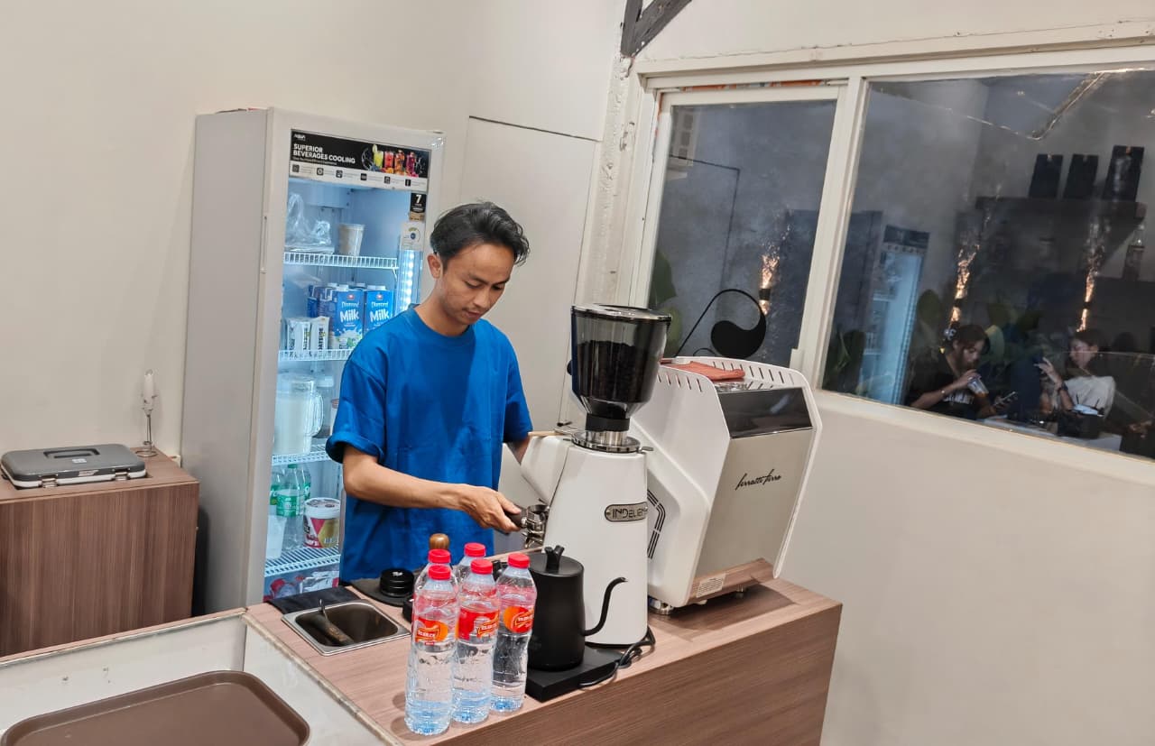 JATUH BANGUN: Owner Skolelo Social Area, Firzain S. Mandai  saat meracik minuman kopi saat ditemui Rabu malam(13/11/2025). Dia suda merasakan jatuh bangunnya berbisnis minuman.