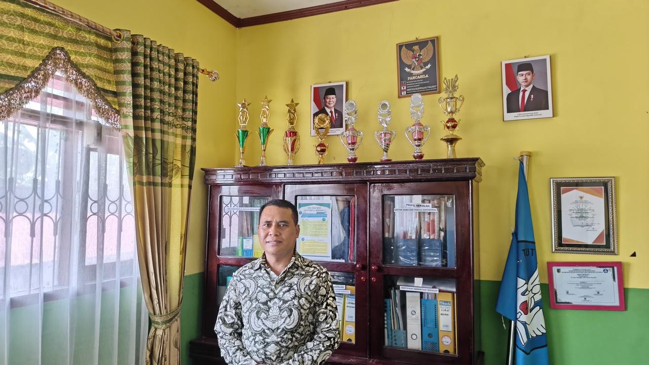 BERPRESTASI: Kepala SDN Inpres 1 Birobuli, La Ntowagi berfoto di depan pajangan piala di ruang kerjanya.