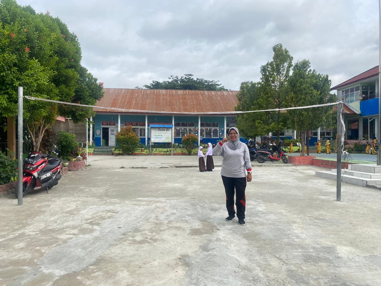 LAPANGAN VOLI MINI:  Plt Kepala SDN 23 Palu, Sri Handayani berada di tengah lapangan voli mini yang dibangun atas inisiatifnya dan berkat gotong royong warga sekolah dan juga perwalian siswa.