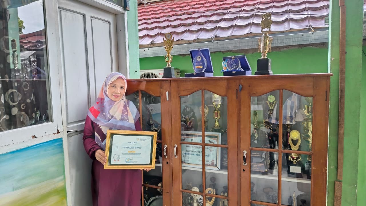 BERPRESTASI: Kepala SMP Negeri 8 Palu Muliana Djabbar memperlihatkan sederet bukti prestasi yang diraih oleh siswa dan sekolahnya saat ditemui pada Jumat (21/11/2025).