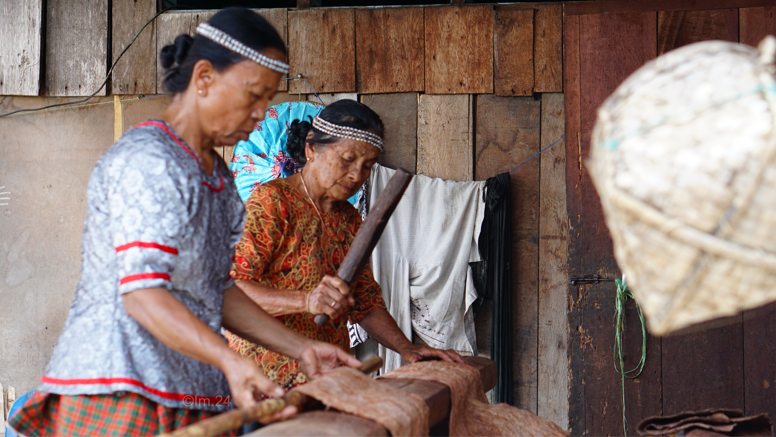 MASIH BERTAHAN: Ina Tobani (kanan) saat melakukan proses pembuatan kain dari kulit kayu.