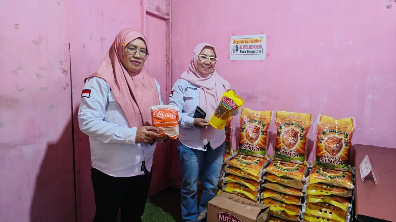 JUALAN DI KOPERASI: Lurah Besusu Barat, Adriani (kanan) didampingi sekretaris kelurahan memperlihatkan beras, gula dan minyak, yang dijual di Koperasi Merah Putih Besusu Barat pada Rabu (26/11/2025).