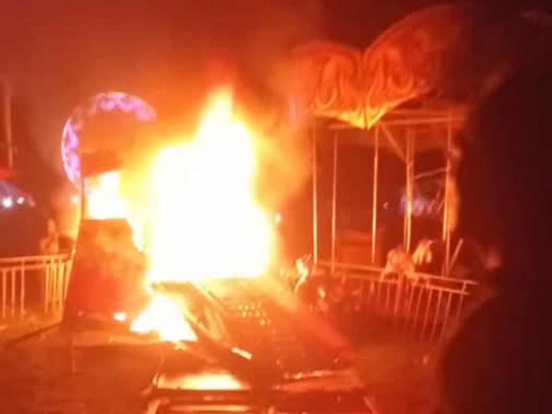 Suasana kobaran api yang melahap wahana Hoya-Hoya di Malino Kabupaten Parigi Moutong usai insiden tragis yang menimpa seorang anak. Warga tampak berkerumun menyaksikan bangunan yang habis terbakar.