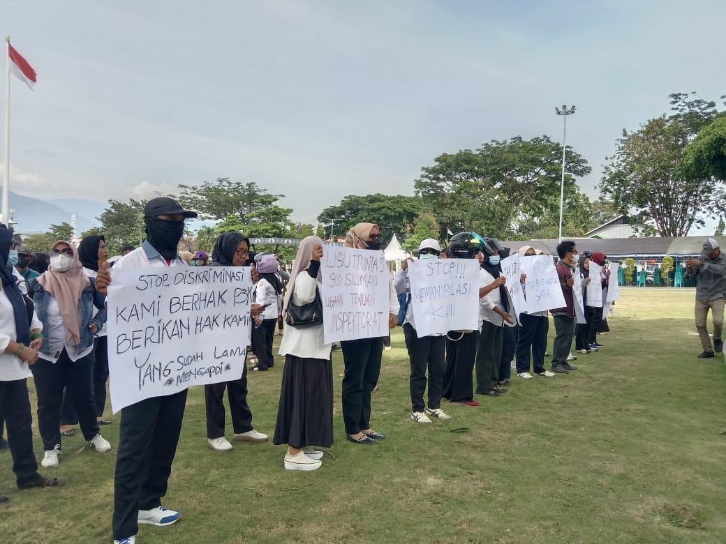 PEMKOT DISOMASI : Ratusan tenaga honorer Kota Palu membentangkan spanduk tuntutan di halaman Kantor Wali Kota Palu, Senin (1/12/2025), saat menyerahkan somasi kepada Pemerintah Kota Palu.