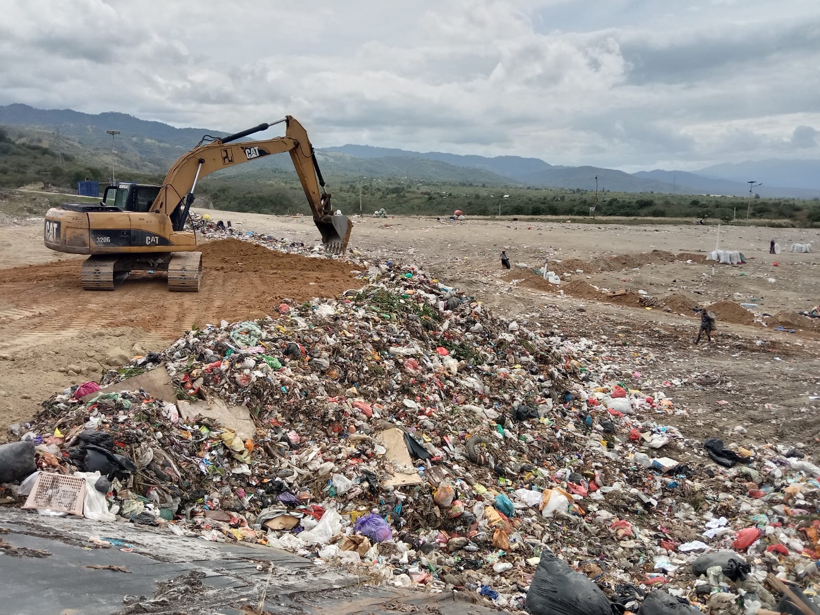 TERAPKAN SANITAY LANDFILL: Alat berat menghamparkan tanah uruk di atas timbunan sampah di TPA Kawatuna, Palu, sebagai bagian dari penerapan sistem sanitary landfill, Kamis (4/12/2025).