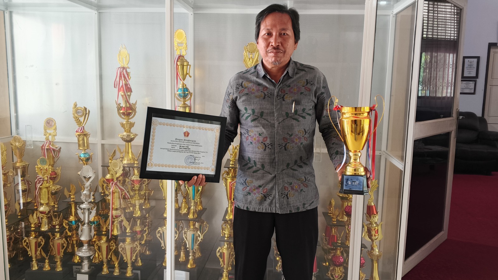 BANGGA: &lrm;Kepala SMPN 3 Palu, Arief memperlihatkan piala serta piagam penghargaan  yang merupakan deretan prestasi siswanya yang berhasil membawa nama baik sekolah ke tingkat kota hingga nasional.