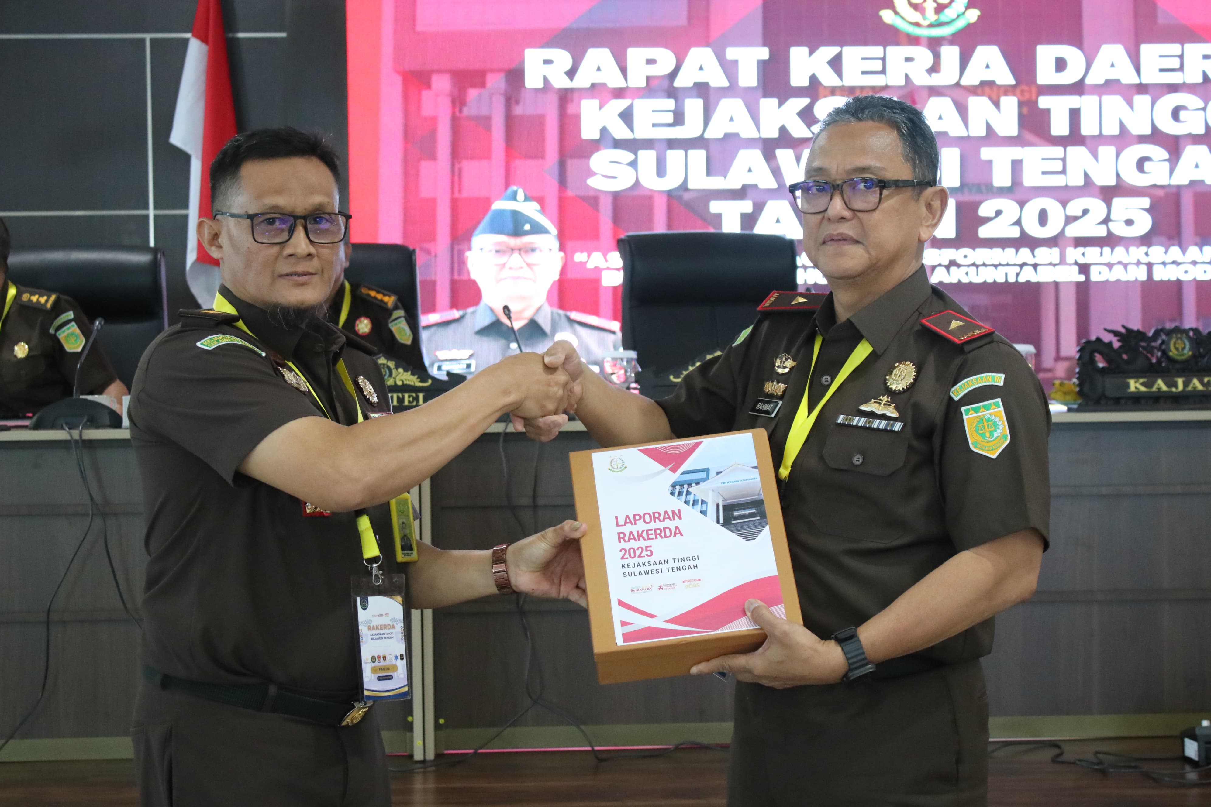 Kepala Kejaksaan Tinggi Sulawesi Tengah, Nuzul Rahmat  menyerahkan dokumen laporan kinerja kepada perwakilan satuan kerja dalam pembukaan Rakerda 2025