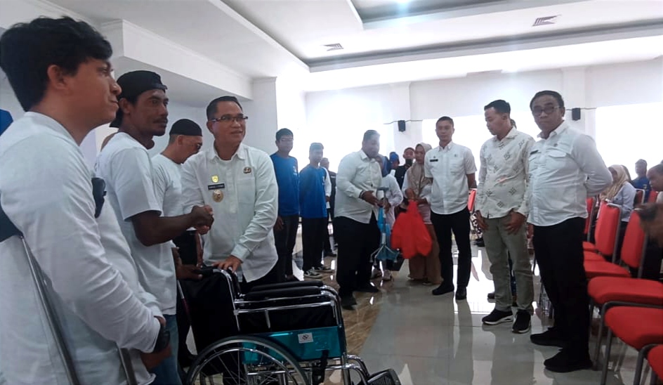 Wakil Bupati Sigi, Samuel Yansen Pongi, menyerahkan bantuan alat bantu dan paket sembako kepada penyandang disabilitas pada peringatan Hari Disabilitas Internasional di Aula Kantor Bupati Sigi