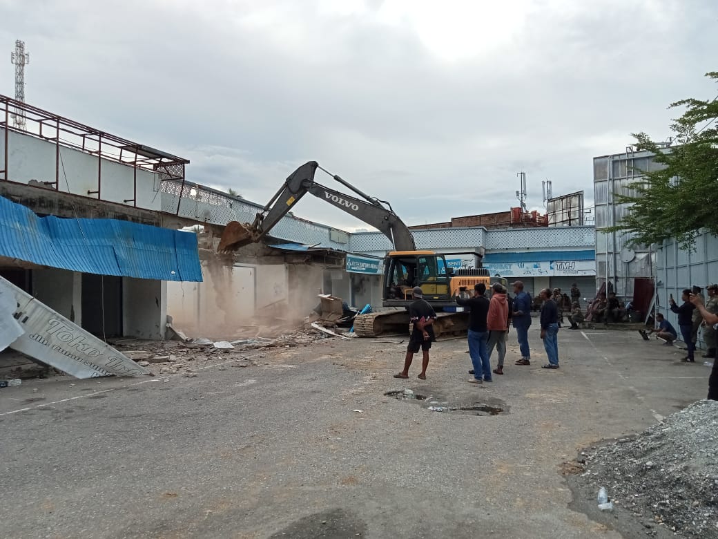 Alat berat mengeksekusi pembongkaran bangunan ruko di depan RTH Jalan Pulau Sumatera, Kelurahan Gebangrejo Barat, Poso, Sabtu (13/12/2025).