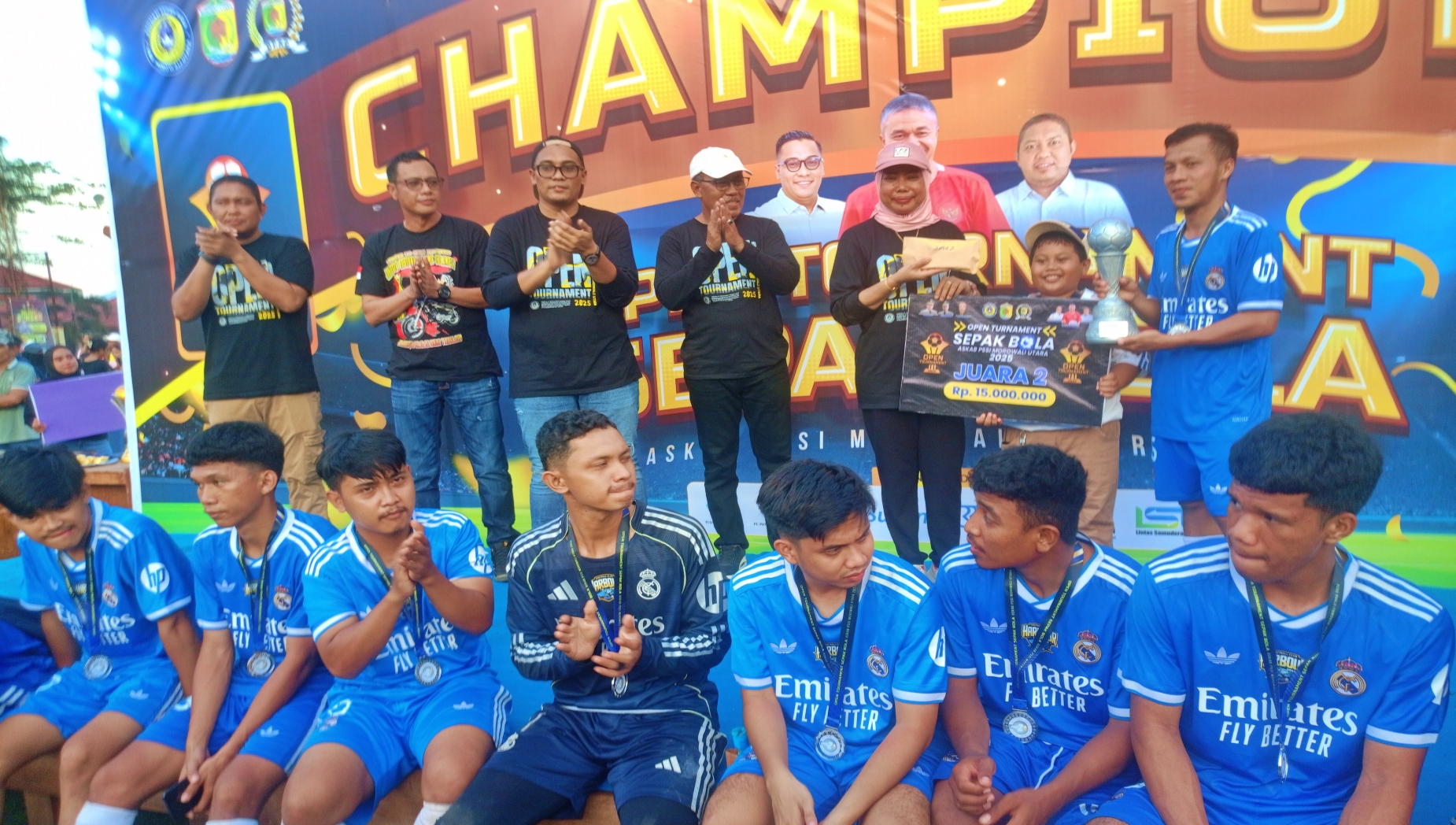 JUARA: Ketua DPRD Morut Warda Dg Mamala menyerahkan piala dan hadiah uang tunai kepada Manajer Harbour FC pada penutupan Open Tournament Sepak Bola Askab PSSI Morut 2025, Minggu (20/12/2025).