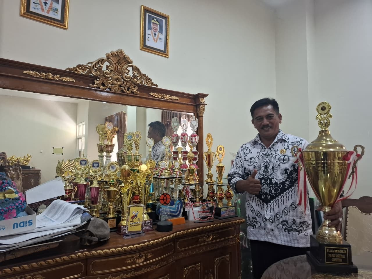 BERPRESTASI: Kepala SMA Negeri 2 Palu, Eddy Siswanto saat  memperlihatkan deretan piala berbagai prestasi akademik dan nonakademik yang berhasil diraih siswa dalam satu tahun terakhir