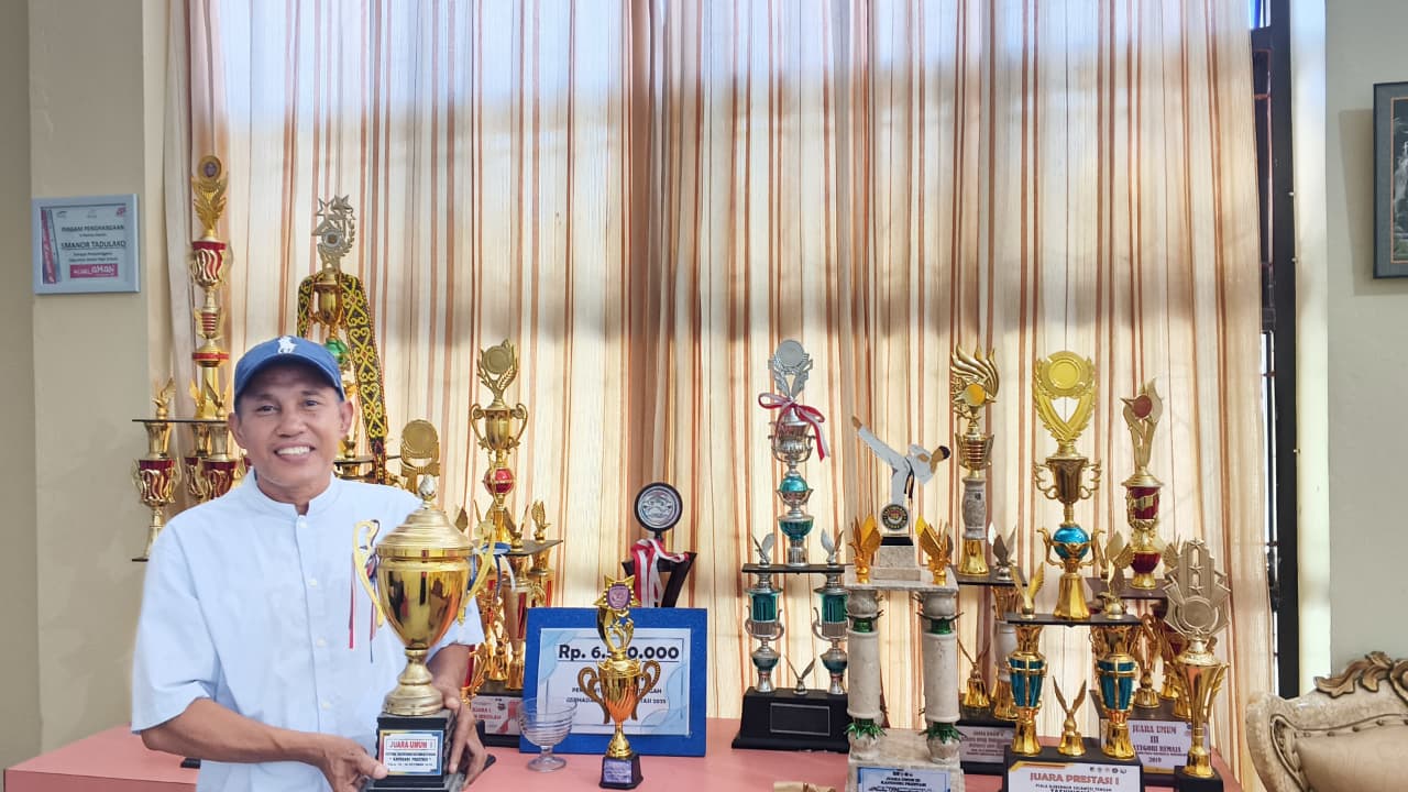 BANGGA: Kepala SMANOR Tadulako, Muhammad Jufri, memperlihatkan berbagai piala hasil capaian prestasi atlet pelajar yang berhasil menorehkan prestasi nasional sepanjang tahun 2025 pada Senin (22/12/25)