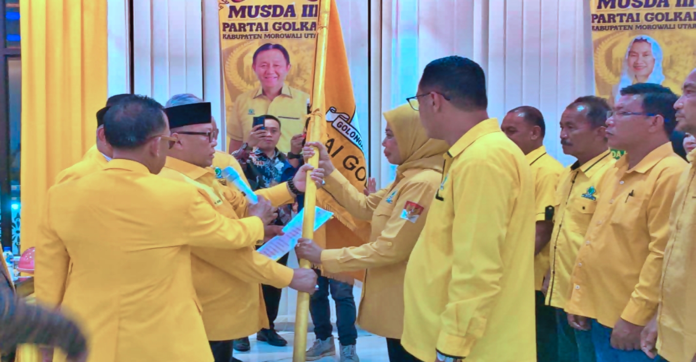 AKLAMASI: Ketua DPD I Partai Golkar Sulawesi Tengah Arus Abdul Karim menyerahkan pataka kepada Ketua DPD II Partai Golkar Morowali Utara Warda Dg Mamala usai terpilih aklamasi, Sabtu (27/12/2025).