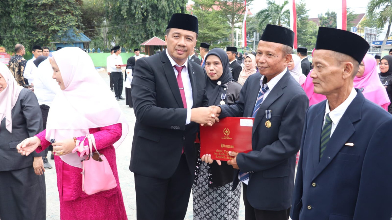 SATYA LENCANA: Kakanwil Kemenag Sulteng, Junaidin menyerahkan satya lencana pada ASN Kemenag Sulteng.(FOTO: DOK HUMAS KEMENAG SULTENG/RADAR PALU).