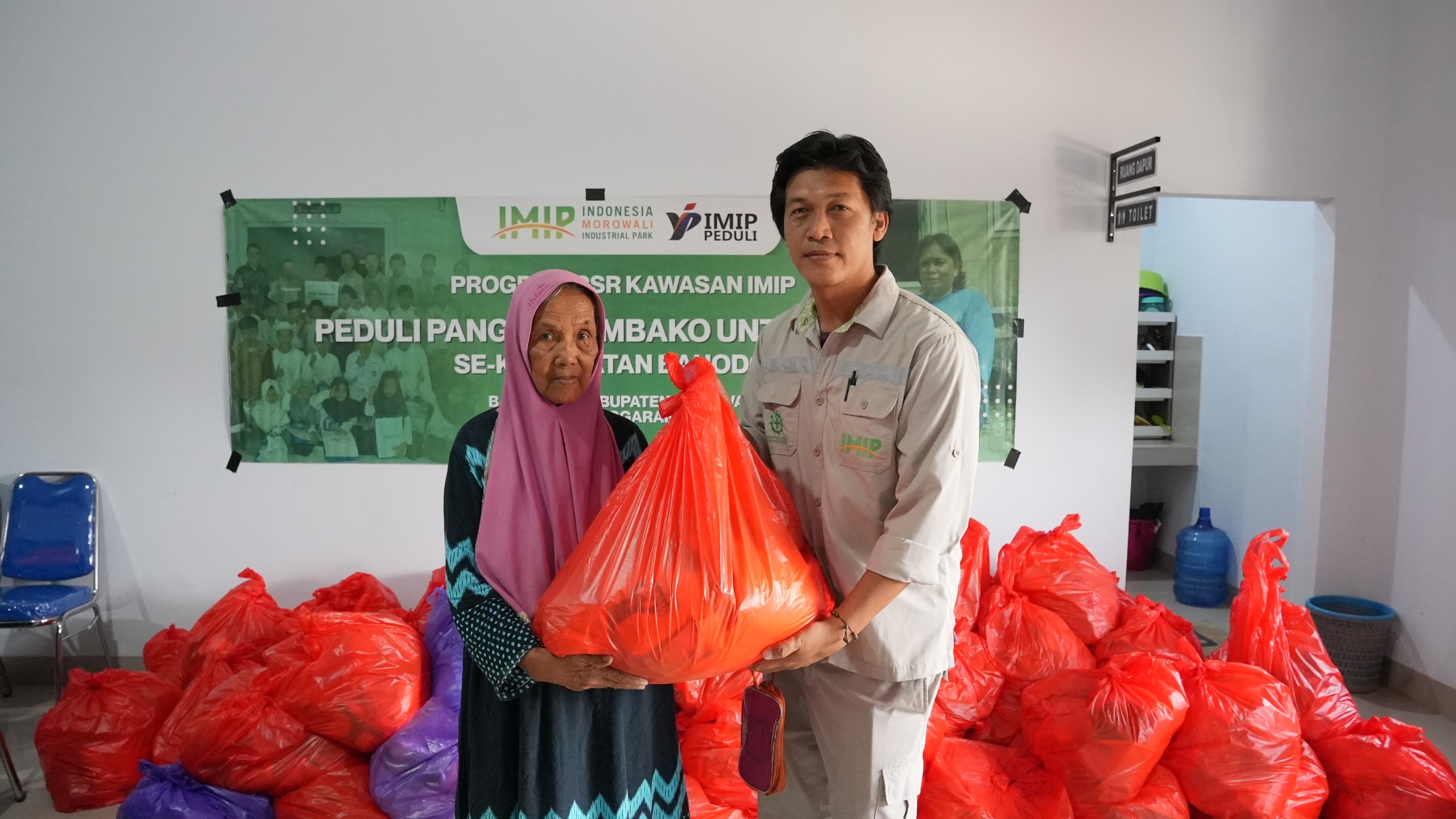 Deputi Direktur Operasional PT IMIP Yulius Susanto menyerahkan bantuan sembako kepada warga Bahodopi melalui Program Peduli Pangan.