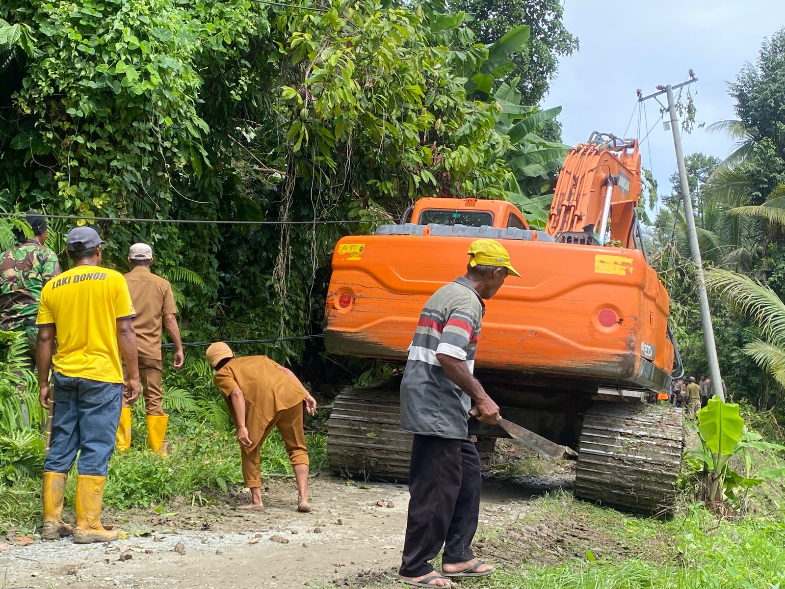 BERSIHKAN MATERIAL : Salah satu alat berat saat membersihkan material longsor di Kecamatan Labuan.(FOTO: ISTIMEWA/RADAR PALU).