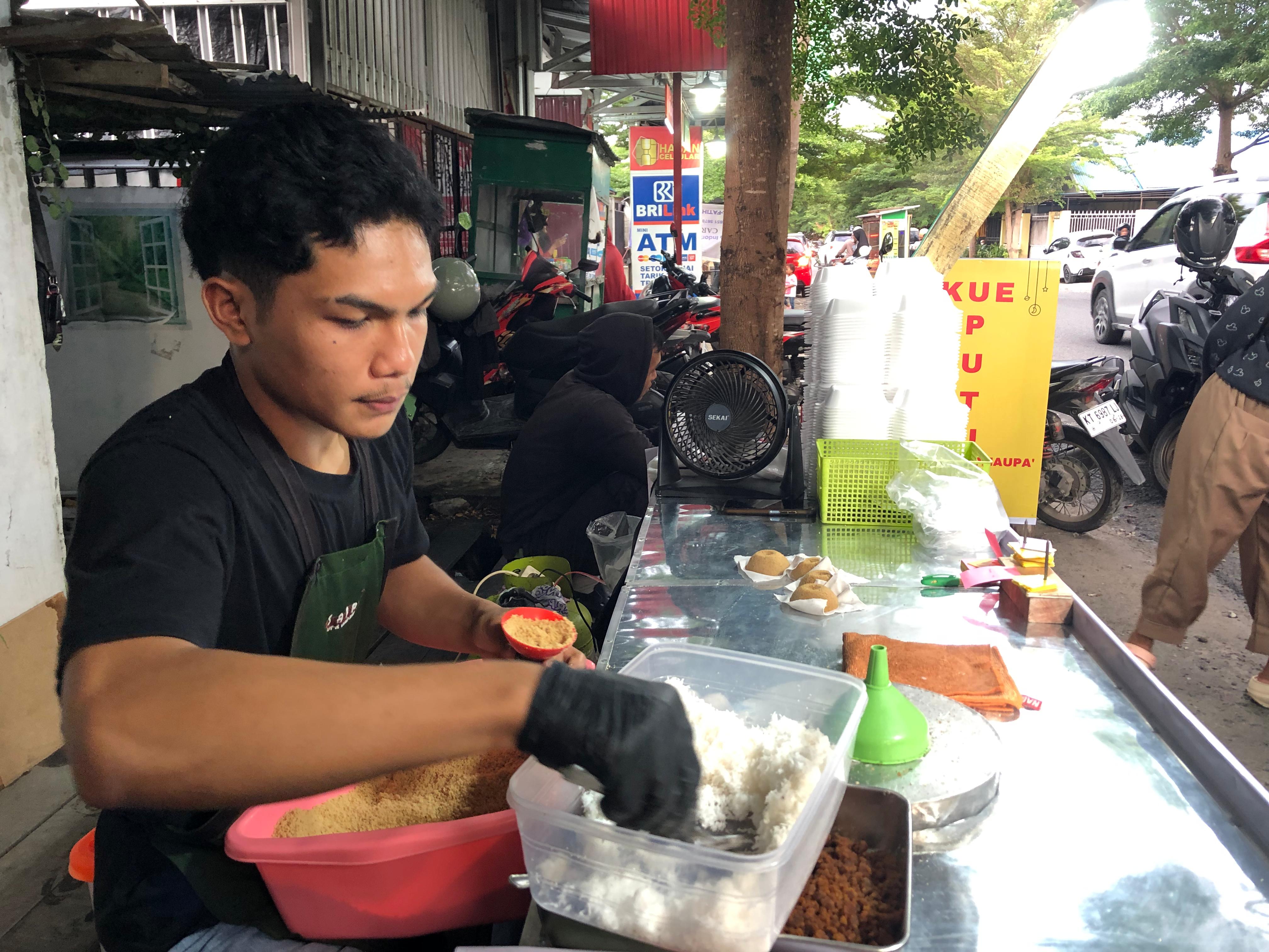 JADI FAVORIT : Pedagang Putu Cangkir asal Makassar, Mursalin, saat menyiapkan putu cangkir untuk konsumen.