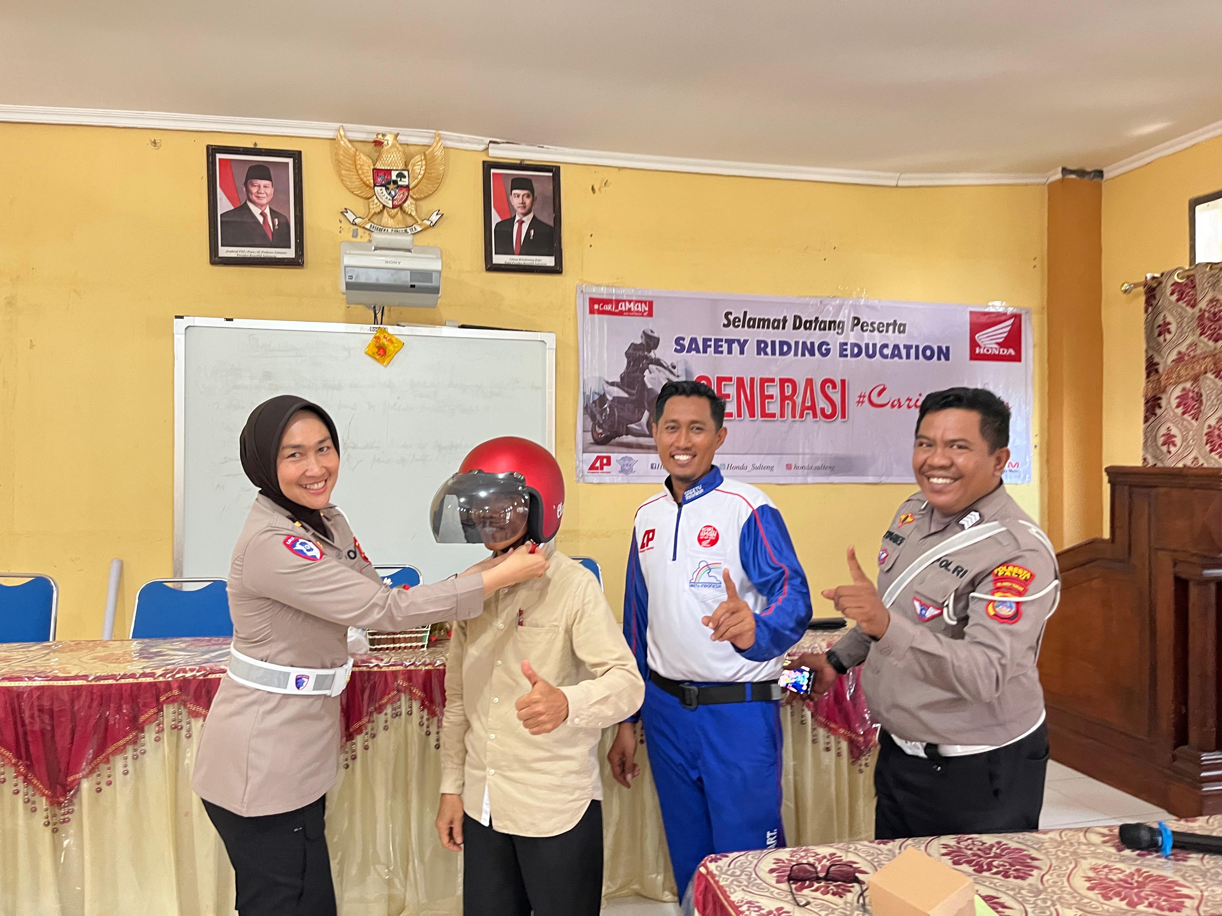 Personel Satlantas Polresta Palu memasangkan helm keselamatan kepada salah satu siswa SMA Negeri 4 Palu sebagai simbol komitmen tertib berlalu lintas.