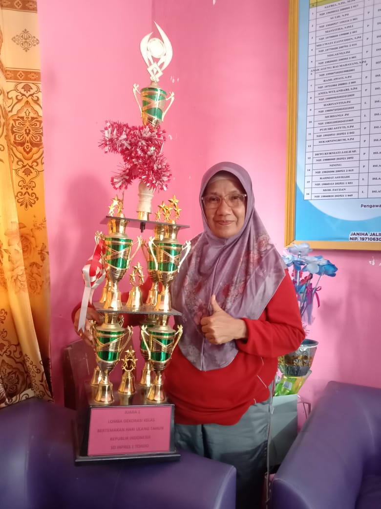 Kepala SD Inpres 1 Tondo, Satria, bersama sejumlah piala penghargaan