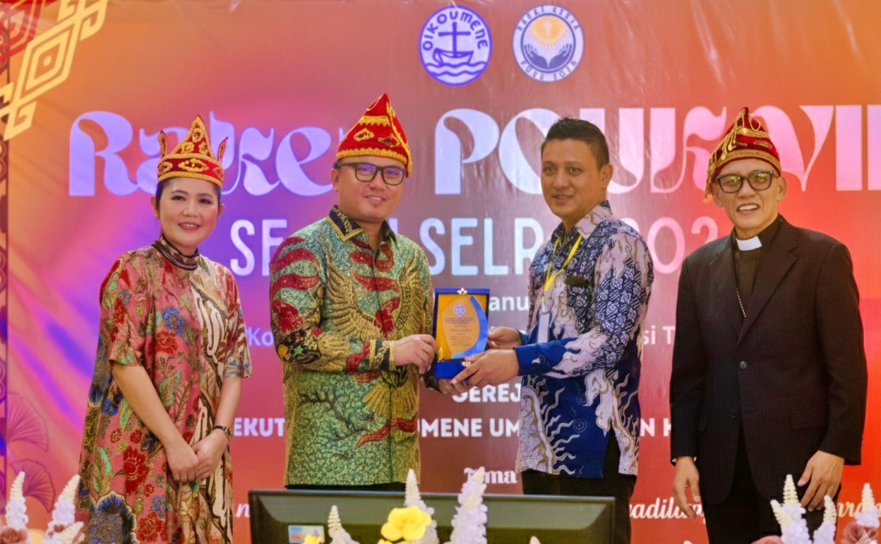 CINDERAMATA: Ketua Panitia Raker POUK VIII Arman Purnama Marunduh, menyerahkan cinderamata kepada Bupati Morut Delis Julkarson Hehi.(FOTO: ISTIMEWA/RADAR PALU)