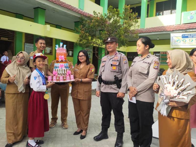 PENGHARGAAN: Kepsek SDN 1 Ampana Kota, Jein Manusama memberikan hadih kepada siswa terbaiknya, Ni Asih Rahayu.(FOTO: HERIYANTO LIMAHU/RADAR PALU).