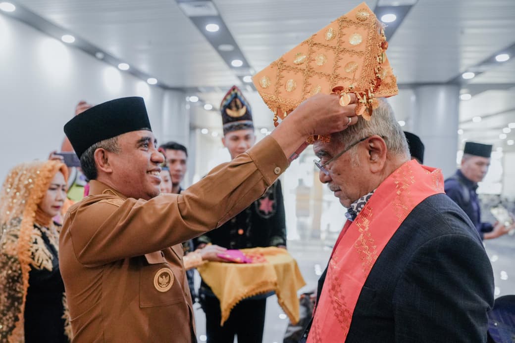 Gubernur Sulawesi Tengah Anwar Hafid memakaikan siga kepada Presiden DMDI Tun Seri Setia Mohd Ali Rustam saat penyambutan di Bandara Mutiara SIS Aljufri, Palu.