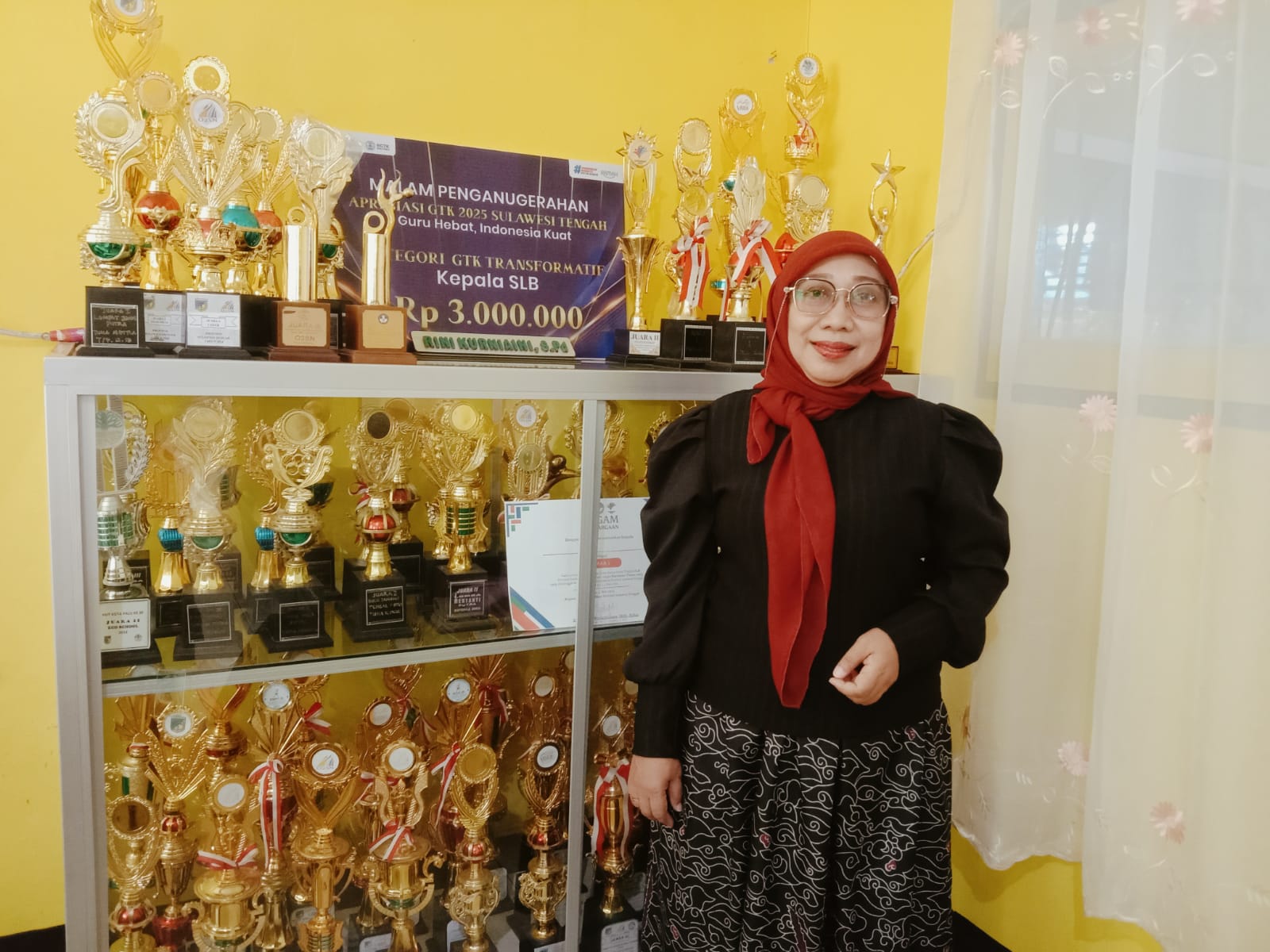 Kepala SLB ABCD Muhammadiyah Palu, Rini Kurniaini bersama piala prestasi seni dan olahraga tingkat provinsi dan nasional.