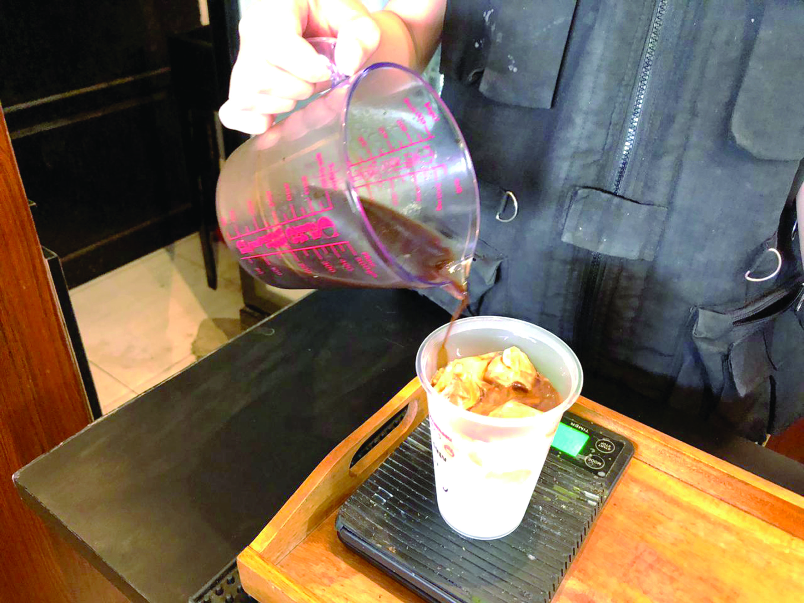 RACIK: Cairan espresso kemudian di tuangkan ke dalam gelas yang berisi susu dan es batu. Ini dilakulan dengan takaran pas sesuai dengan jenis minuman kopi yang dipesan oleh pembeli.