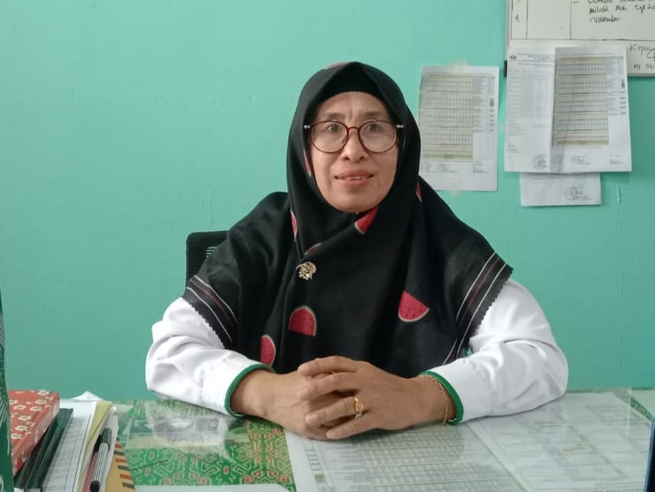 Kepala MTs Muhammadiyah Al-Haq Palu, Hj. Mizan, menjelaskan komposisi guru PNS dari dua instansi berbeda di sekolah yang dipimpinnya.