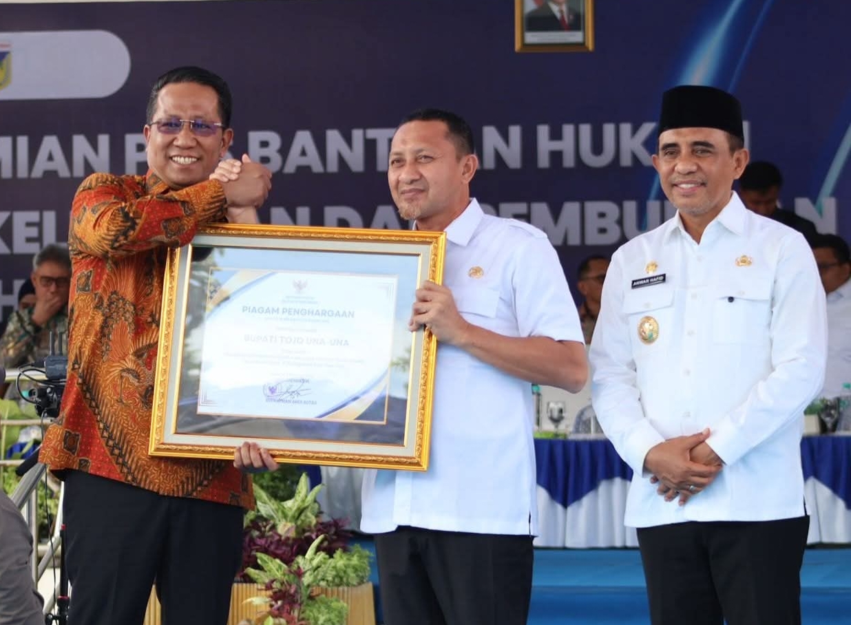 PENGHARGAAN: Bupati Touna, Ilham Lawidu, saat menerima pengharagaan Posbankum dari Menteri Hukum.(FOTO: ISTIMEWA/RADAR PALU).