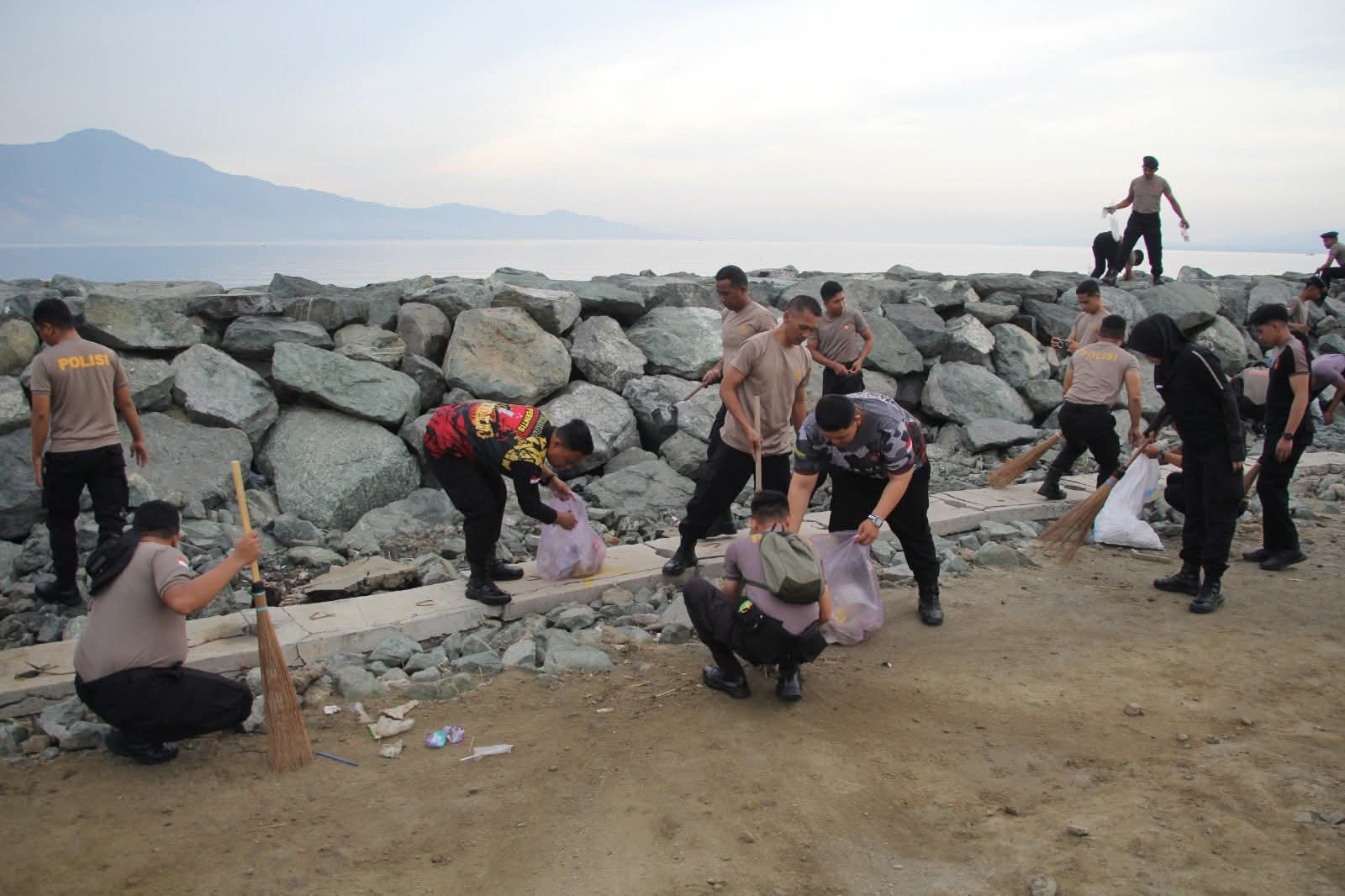 Personel Polresta Palu membersihkan sampah di kawasan Pantai Talise hingga batu Kampung Nelayan (Kamnel), Selasa (10/2), sebagai upaya menjaga kebersihan ikon wisata Kota Palu.