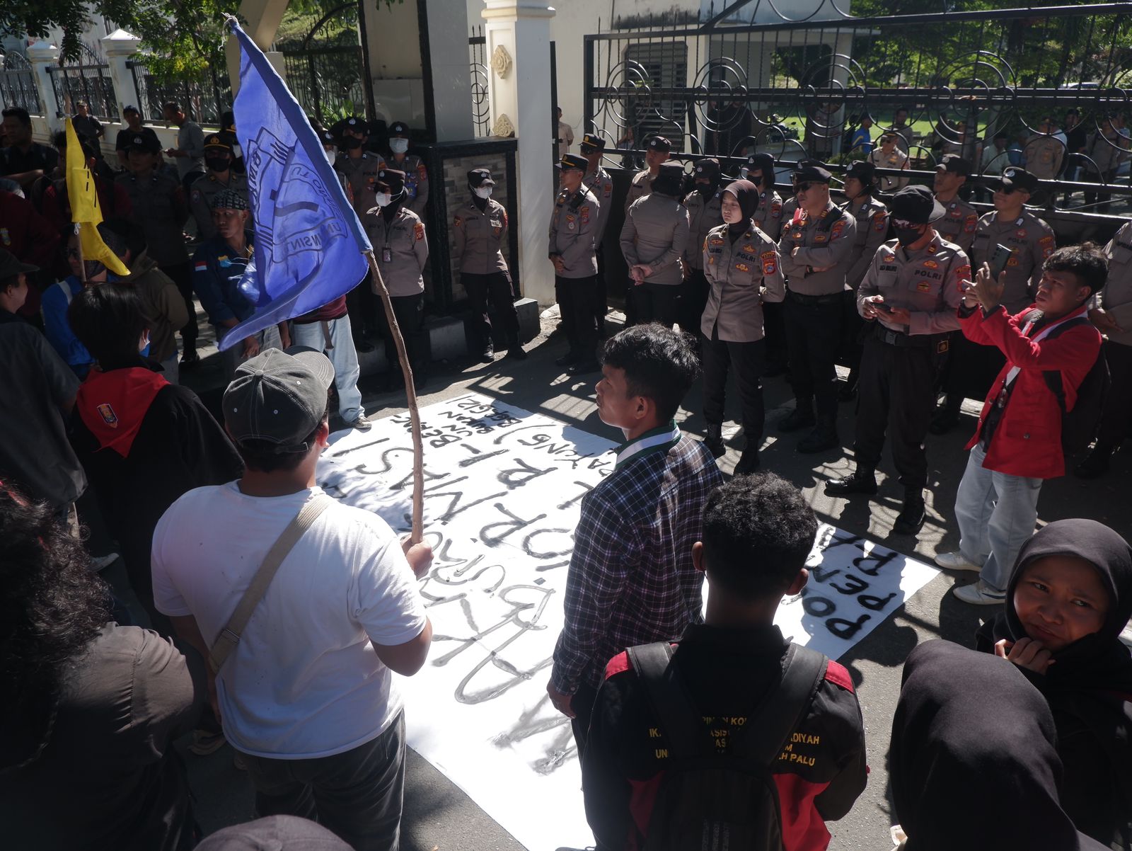 Mahasiswa menggelar aksi di depan Kantor DPRD Sulawesi Tengah, Jumat (27/2/2026), menyuarakan evaluasi program MBG dan tuntutan dialog resmi dengan pemerintah daerah.