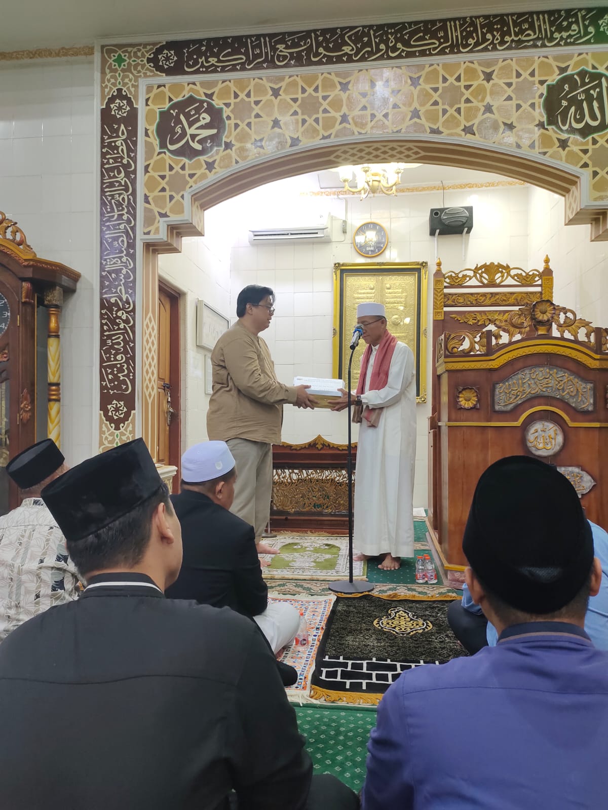 SILATURAHMI: Kabag Persidangan DPRD Sulteng, Asmir Julianto Hanggi mentyerahkan bingkisan berupa Alquran kepada pengurus masjid di Banggai.(FOTO: HUMAS DPRD SULTENG/RADAR PALU).  