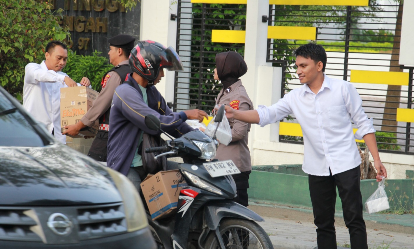 Personel Polresta Palu membagikan paket takjil kepada pengendara yang melintas Jalan Samratulangi.